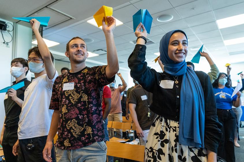 Students throwing paper airplanes.